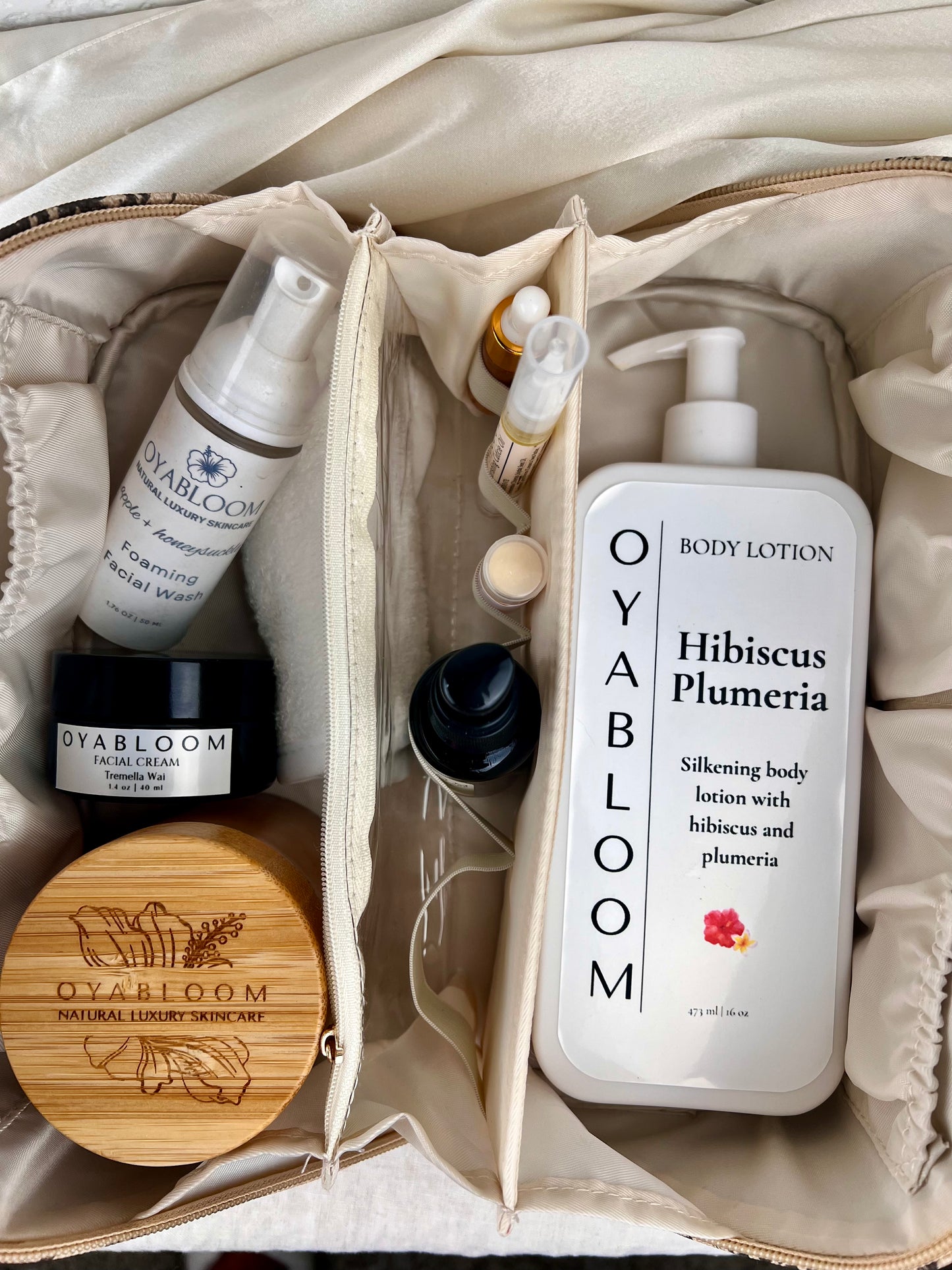 Oyabloom Hibiscus Plumeria Body Lotion 16 oz pump bottle packed in a travel bag with other Oyabloom skincare
